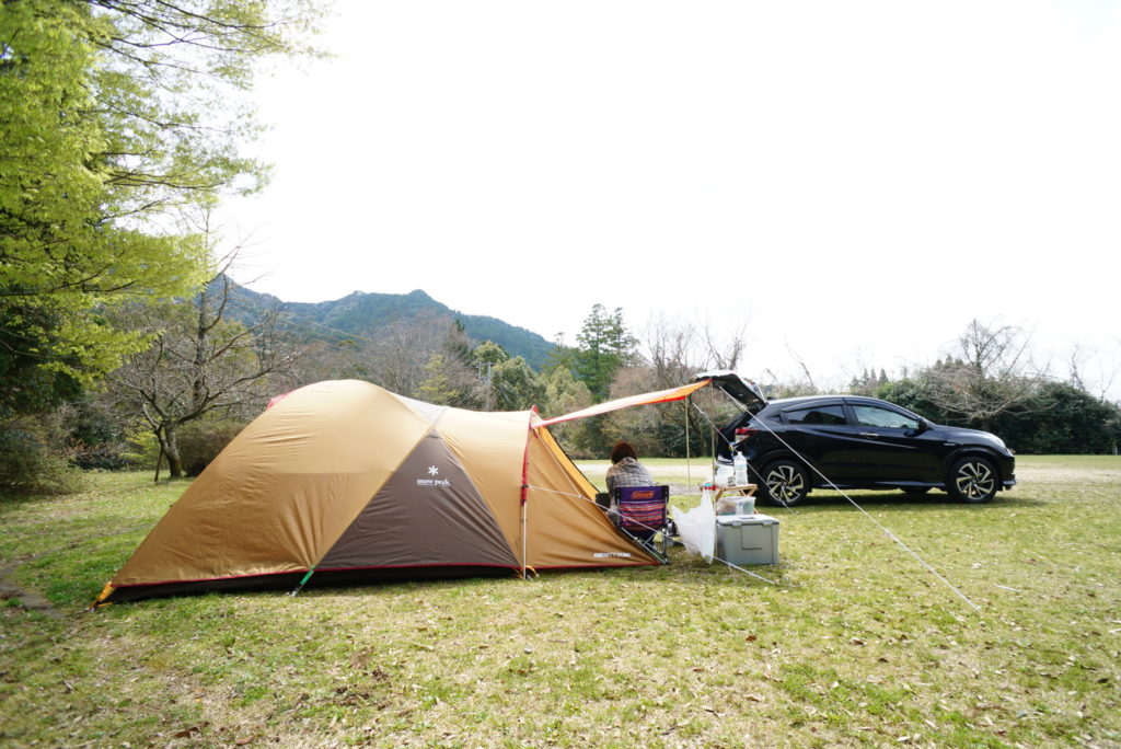 ドームテントと椅子、車が見えるキャンプ風景