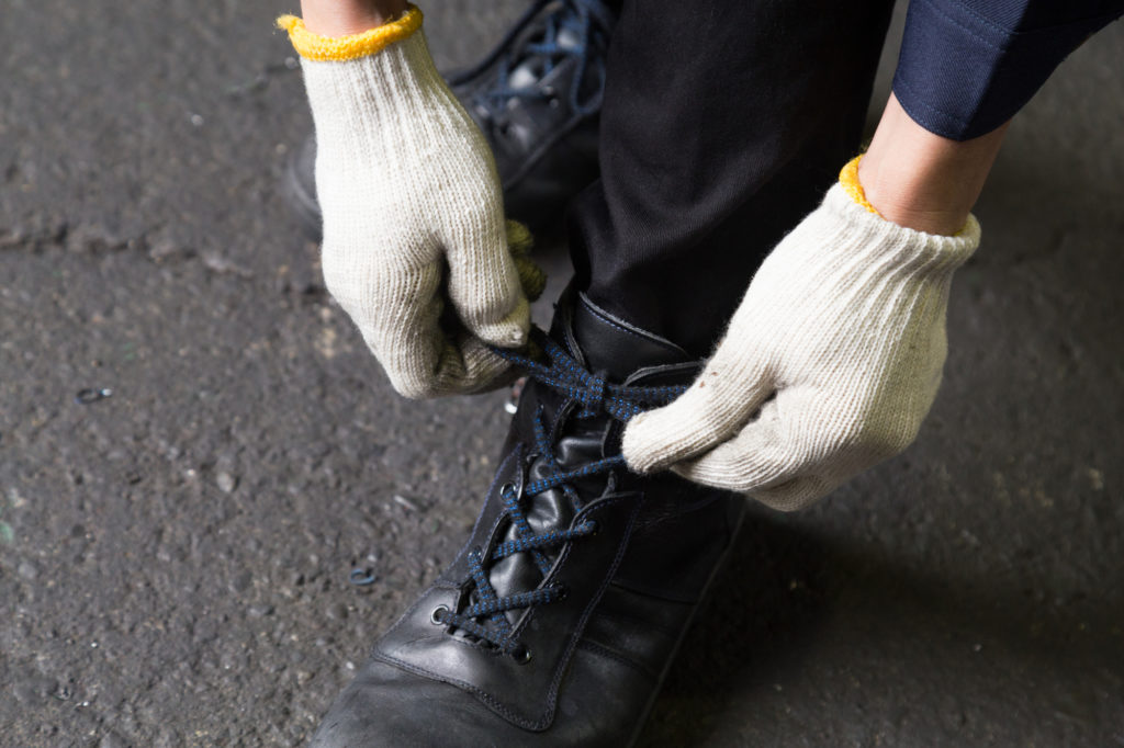 靴紐を結ぶ男性と安全靴のイメージ