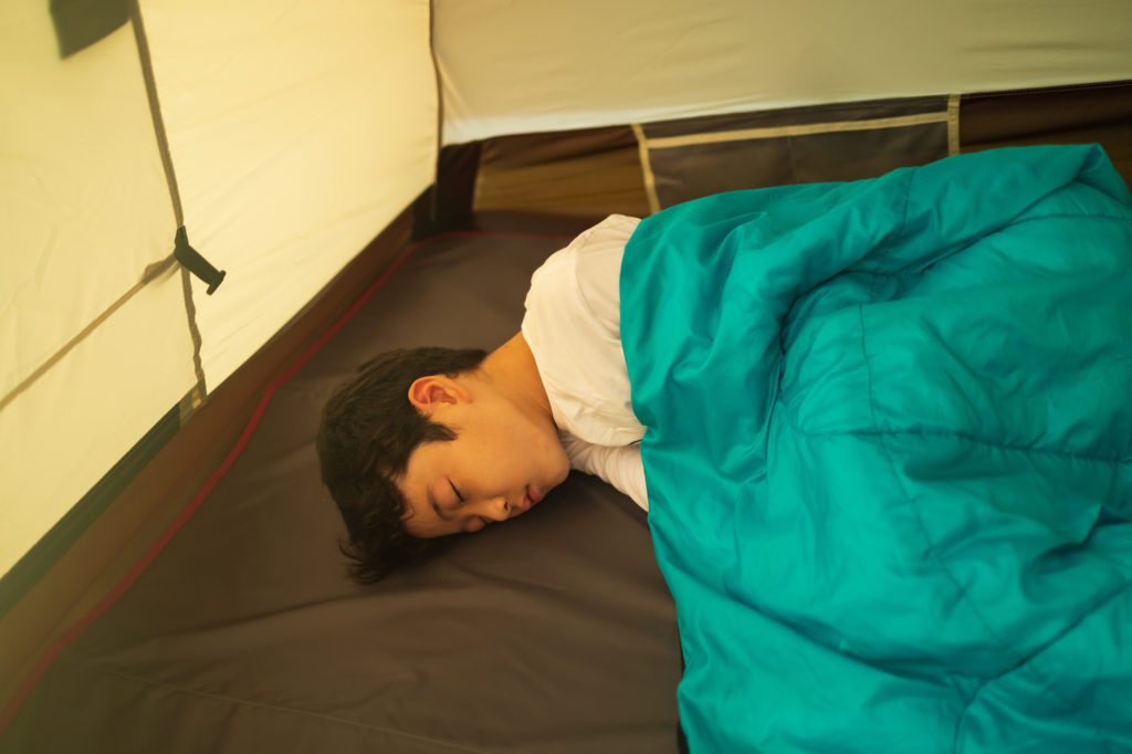 テントの中で熟睡する子供